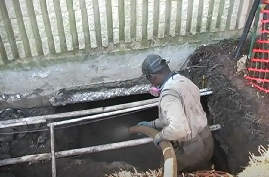 Peterson crew member in a trench guiding a vac hose
